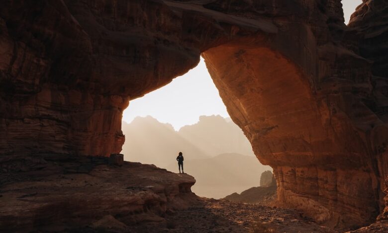 a person standing at the entrance to a cave